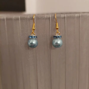 Örhängen  - Örhängen. Ljusblå pärla med blå strass.