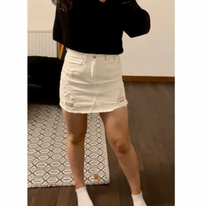 Vit jeanskjol med slitningar  - Vit jeanskjol med slitningar. Köpt för ett tag sedan men inte använd över fyra gånger, därav i väldigt bra skick. Storlek: S. 40kr+ frakt💕