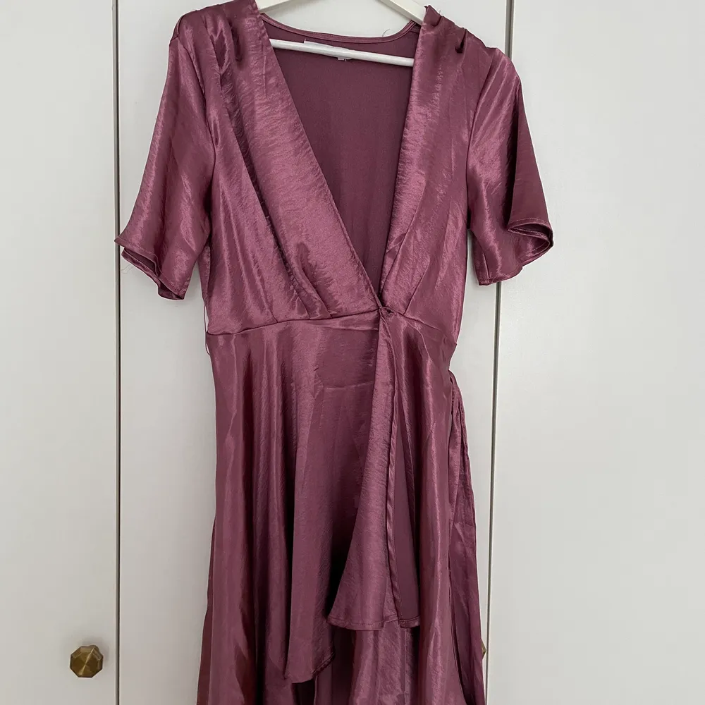 Omlott-klänning i skimrande mörk rosa från NAKD, aldrig använd - storlek S. Klänningar.