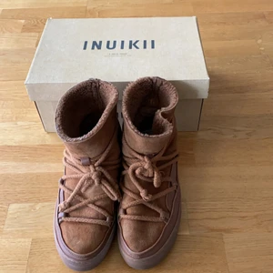 Inuikii skor  - Säljer mina så snygga Inuikkii skor i brun, passar jättebra till hösten och vintern då de håller värme superbra! Har några slitningar där bak som man ser på tredje bilden, därav priset💞 Köpte för 2500kr säljer för 500kr🥰 Bud på 900