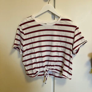 T-shirt med knut - T-shirt från H&M i storlek L. Har en knut fram på magen. Väldigt skön.