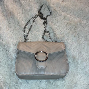 väska - säljer denna väskan, köpt för 2 år sedan men ser fortfarande ny ut, ny pris 279 ksk, säljer pågrund av att jag inte använt på ett år, jätte fin väska med ett mindre fack i, får plats mycket och är väldigt fin och lätt att matcha med allt, färgen är beige. 