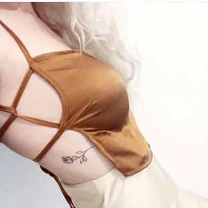 Topp med snören - Topp med öppen rygg och snören, i satinmaterial. Från Nelly i storlek 40 (passar mig som har S men lite större byst än modellen). Använd 1 gång. 