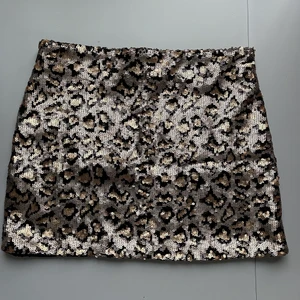 Pajettkjol från Zara - Guld/svart paljettkjol från Zara, med zipdragkedja på sidan (se bild 2). Använd 2 gånger, storlek XS. Frakt ingår i priset 