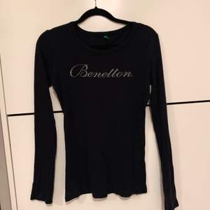 En tröja ifrån Benetton som är figursydd, stretchig och märkets namn på bröstet är i glitter. HALVA PRISET PÅ FRAKTEN 