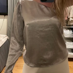 Blus - En enarmsblus i silver! Jätte fin på, sitter skönt och har även en liten slits längst ner på armen, finns slitage man det sticker inte ut och man tänker inte på det! Köparen står för frakten! 🌞