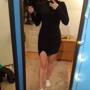 Svart ribbad klänning med slits - Svart klänning i ribbat tyg med en slits på ena benet. Endast provad då det inte riktigt är min stil. Storleken är Small, men pga väldigt mjukt och stretchigt tyg passar den lätt någon med M. Stilren klänning som passar perfekt till sommarn eller nyår!🎉