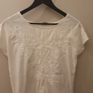 Vit tshirt med detalj - Fin vit tshirt med broderade detaljer framtill. Strl M. 