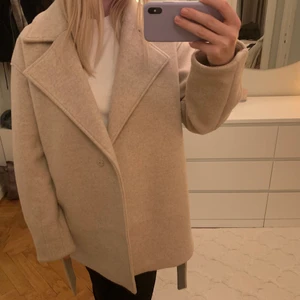Beige kappa NAKD - En kappa i ullblandning från Nakd. Kortare modell. Köpare står för frakt. Nypris 799. Snygg både med och utan band. Oversize (strl 36) på mig som har XS oftast. 
