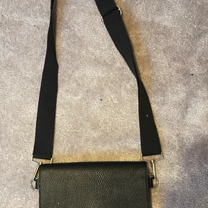 Väska från monki - Svart väska med axelband från Monki. Obs. vet ej vad frakten kostar
