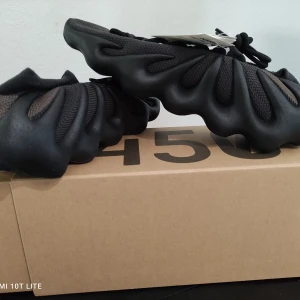 Adidas Yeezy 450 dark slate - Säljer ett par Yeezy 450, oanvända.  Skorna är enbart upplockade för bild.  Storleken är 45 1/3  Svarta  Kvitto från adidas medföljer Passa på innan dessa stiger upp i pris!