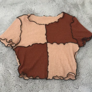 Brun beige T-shirt  - Säljer denna bruna/beiga croppad T-shirt med sömmar. Jag har använt denna ett fåtal gånger, men den är ändå lite lite nopprig, men det syns inte på håll.