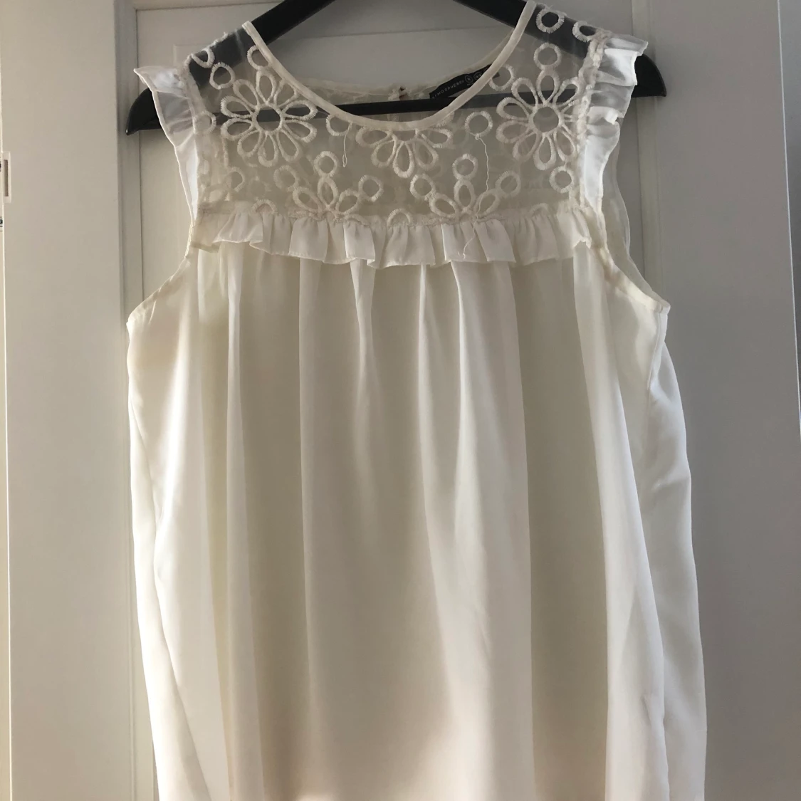 Armlös blus med transparenta blommor 