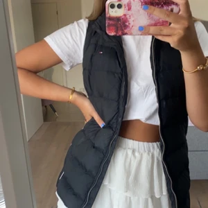Tommy hilfiger väst  - Svart Tommy Hilfiger väst med röd vita räder på sidan. Säljer då den inte kommer till användning.  Stl XXS men skulle säga att det är en mer XS då jag i normala fall alltid har XS .Köpt i USA för 3000 kr , säljer nu för 1500 kr.
