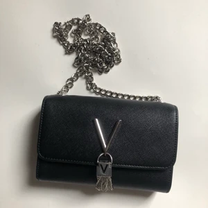 Valentino väska - Maxbud 500! Skitsnygg & stilren väska från Valentino! Inte använd en enda gång pga att det var en present från en avlägsen släkting som inte visste vad jag hade för stil. Långt axelband & en liten ficka på insidan samt större utrymme för plånbok, nycklar & mobil osv. 