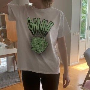 Ganni t-shirt - Jättefin populär t-shirt från Ganni, använd kanske 4 ggr, köpt för 1100kr, budgivningen pågår fram till söndag 16.00. Köp direkt 800kr😍