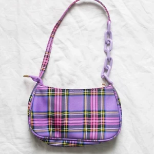 Lila axelväska - Superfin lila, rutig axelväska 💜 Helt ny! Kika in mina andra annonser, 3 för 2 på alla väskor. Väskan kostar 99kr, inklusive frakt! 