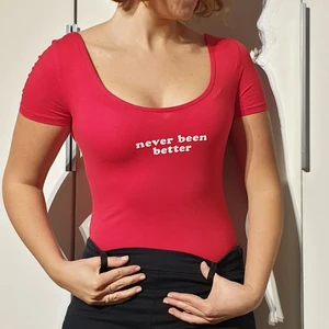 Röd topp, storlek S - Röd tajt body topp med vit Never been better text. Bomull.