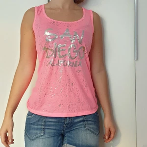 Rosaneon topp, storlek S - Rosa neon topp med San Diego California silvertext. Halvöppen ribbad rygg.Bomull. ❣Har ingen tvättext❣ 