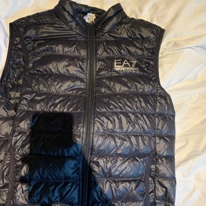 Ea7 Armani väst - Detta är en fin väst nästan som ny skick endast ett litet hål som knappt syns. Den är i storlek L men passar perfekt på M. Pris kan diskuteras men ärliga köpare 