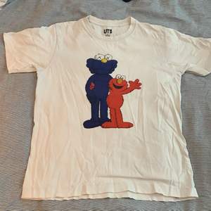 KAWS Sesame street t shirt från UNIQLO. Använd en del fast fortfarande bra skick trycket är fortfarande perfekt. Sitter mellan en S och M