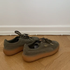 Puma Suede strl 38.5 - Ett par gröna puma skor med guld detaljer. Helt nytt skick, enbart använda en gång. Pris kan diskuteras 