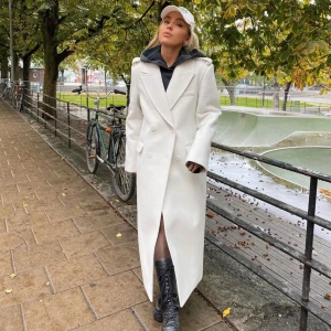 Vit kappa NAKD X Angelica Blick - Vit super snygg kappa från Angelica Blicks kollektion med NAKD! Har aldrig använt den så den är helt i nyskick, kan självklart skicka bilder på den på mig!