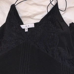 IRO linne - Svart urringat linne från IRO. Spagettiband och fina sömmar och spetsdetaljer. Det är lite längre på sidorna . Storlek 36 men skulle själv påstå att den kommer passa bäst på 38-40