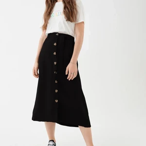 Gina Tricot kjol  - Kjol med knappar från Gina tricot. Använd Max 2 gånger. Midi längd med knappar längst mitten och band i midjan. Storlek 34. 