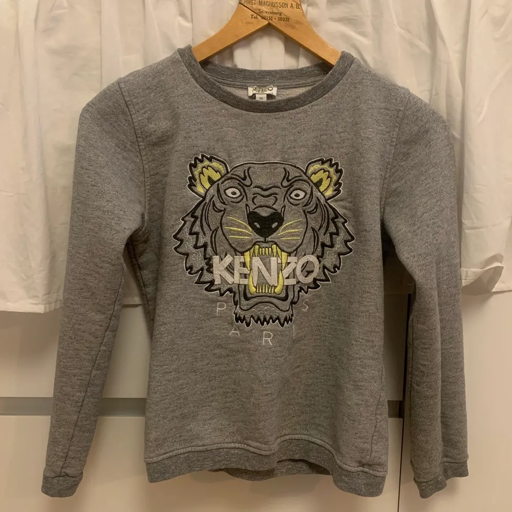 Grå sweatshirt från Kenzo, med gula och glittriga detaljer. Egentligen från Kenzo Kids avdelningen men passar XS. Använd mycket men utan synliga slitage,  kvaliteten är 10/10! . Tröjor & Koftor.