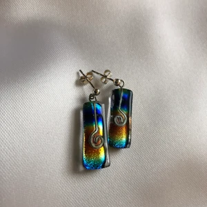 Handgjorda örhängen i glas - Handgjorda örhängen i glas och silver (925). Regnbågsmönster med silverinlägg. Ca två cm.    Aldrig använda. 
