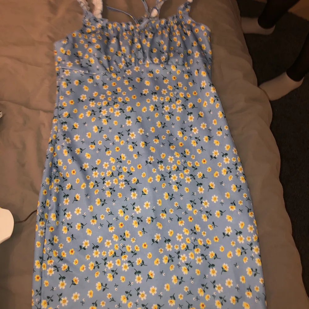 Jättefin blå klänning med gula blommor som tyvärr inte kommer till nån användning. Storlek XL men passar bra för mig som har M, så den är ganska liten i storleken. Köparen står för frakt!. Klänningar.