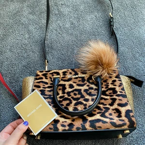 Leopard/guld limited edition väska. - En sjukt ball limited edition handväska från micheal kors. Den stora modellen. Nedgår även en ”pälsboll” som man kan ta av om man vill men jag tyckte den va ball där ;)! Sjukt rymlig, najs fack inuti! Den har avtagbara och reglerbara band. Köpte för några år sedan men får tyvärr ingen användning av den längre. Använd 2 gånger. 100% äkta - har dustbag och äkthetsbevis, som syns på bilden. Nypris : ca 4000kr