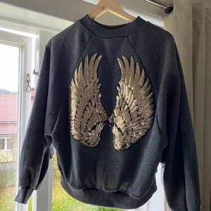 Super cool collegetröja  - Säljer en av mina favorit collegetröja. Köptes i Spanien i somras. Har bara kommit till användning en gång. Vingarna är baksidan av tröja. Ordinarie pris är 489kr men säljer för 300kr❤️ (inga av paljetterna har trillat av)