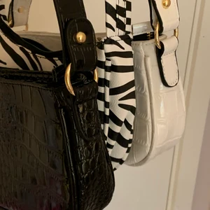 Axelväskor/ zebra svart o vit. Baguette - Tre olika baguette bags. En svart, en zebrarandig och en vit. 50kr styck eller alla för 130kr+frakt=66. Om ni bara köper en väska är frakten 66 !OBS SVARTA SÅLD! 