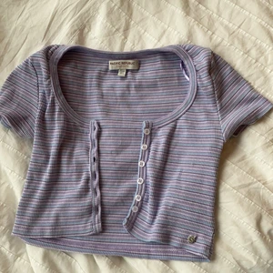 Randig Button up! - En blå, pastell lila, vit button up från and bear. Stretchiga material som passar delats olika storlekar. Superfint att ha som kofta över ett linne eller bara själv. Passar med det mesta och jag har bara använd det några få gånger. Den är i storlek s men den är ganska liten i storleken.FRI FRAKT!