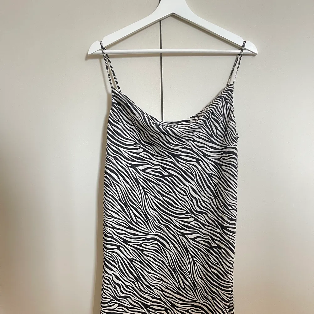 En långklänning med zebra mönster från h&m. Med öppning på vänster ben och justerbara band. Väldigt bra skick, använd 2 gånger. Köptes för 200kr och säljer för 90kr + frakt.. Klänningar.