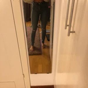 Blå ripped jeans - Högmidjade blå slimjenas med hål på knäna. Strechigt material. Modell: 165 cm