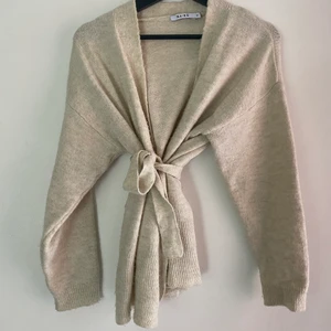 Nakd tjocktröja  - En beige fin tjock tröja / kofta. Funkar att ha själv, men oxå som bara kofta med en tröja under. Bandet går att spänna så mycket man vill. Ger en fin midja och byst. Funkar till allt! Väldigt skön oxå!!