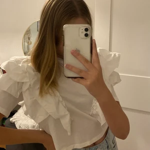 Vit volangtopp - Säljer nu denna fina vita volang topp från Ginatricot! Aldrig använd. Köpare står för frakt.