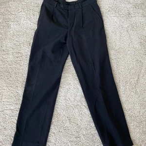 Mörkgråa kostymbyxor - Ett par mörkgråa kostymbyxor med okänt märke, bra skick på byxorna. Står ingen storlek men skulle säga att de sitter som ett par i storlek 50