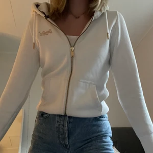 Superdry vit zip hoodie  - superfin ziphoodie från Superdry i storlek 38! säljer då den är lite kort i armarna på mig som är väldigt lång. den är i superbra skick då den endast är använd 1-2 gånger!! köparen står för frakten 💓💓