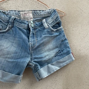 Blåa Levis Jeans  - Blåa Levis jeans storlek 12 år. Med turkosa retro knappar samt ljusa sömmar. Detaljer på bakfickan, mycket stretchiga och sköna :) 