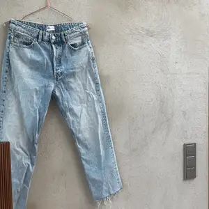 Ett par raka blåa zara jeans med 4st silvriga knappar istället för dragkedja. Små rostfärgade detaljer i form av halva knappar samt sömmar i likadan färg. 