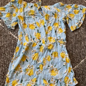 Off-shoulder jumpsuit från Gina Tricot - Ljusblå mönstrad kort jumpsuit med citroner i storlek 36 i ny kondition