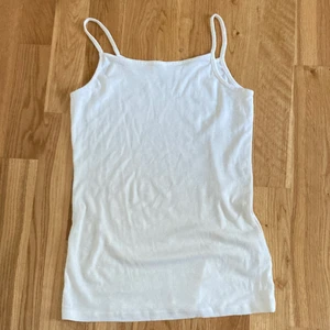 Ett vitt linne - Linnet är från Lindex. Nästan aldrig använt. Fint skick! Storlek:170. 