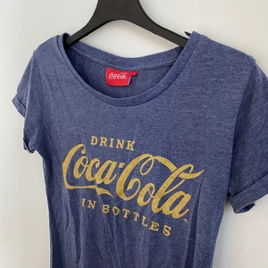 Coca Cola T-shirt - Blå, spräcklig T-shirt med Coca Cola logga på. 