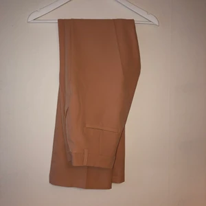 Rosa/Beige byxa - Byxan är rosa/beige blandat, väldigt fint färg och väldigt len material. I storlek 36. Helt ny