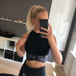 Träningstopp - Cool svart träningstopp från Nike! Toppen har två band som går omlott framtill samt en liten öppning nedtill bak i ryggen. Använd endast ett fåtal gånger 🥰