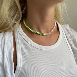 Grönt halsband - Superfint handgjort halsband med hälften gröna pärlor och hälften benvita. Förslutning bak med lås och tre ringöglor för justering samt en silvrig stjärna. 
